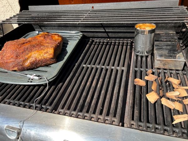Indirect heat setup: right 2 burners on with smoker box + water can topped with hickory chips for extra smoke. Brisket chilling on the cool left side—low, slow, and ready to shine.